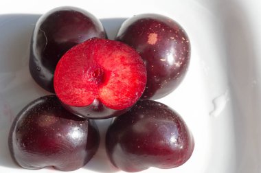 Küçük sulu, yenilebilir meyveli erik ağacı. Büyük bir kemiği var. Olgunlaştığında mor, kırmızımsı veya sarı olan oval etli bir meyve ve düz uçlu bir çukur içerir..