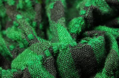 Doku, arka plan deseni. Bir insanın boynuna takılacak yün bir eşarp. Atkıda yeşil siyah renk