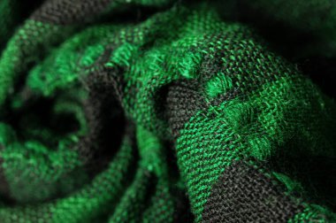 Doku, arka plan deseni. Bir insanın boynuna takılacak yün bir eşarp. Atkıda yeşil siyah renk