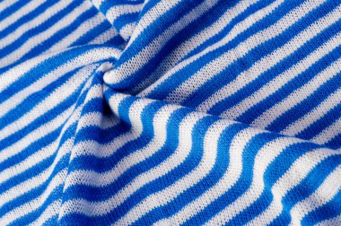 Beyaz ve mavi çizgili kumaş. Örgü örme, iplik dokuma ya da ilmek dokuma işlemi sonucu elde edilen bir kumaştır..