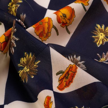 İpek kumaş. Çiçek desenli beyaz ve mavi kareler. Çiçekler kırmızı-sarı. Doku arkaplan modeli. Çiçek izinden, kumaş ilkbaharda soluyor ve keyfi yerinde..