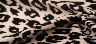 Doku, arkaplan, desen, kadın yün şalı, siyah ve bej, Afrika motifleri, yün ve modülden yapılmış, kenarları kıvrımlı bir yılan şeklinde..