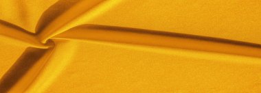 Sarı ipek. Pürüzsüz, zarif, sarı, lüks ipek kumaş kopya alanı olan soyut bir arkaplan olarak kullanılabilir. Renkli doku