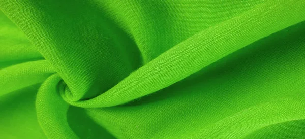 Yeşil ipek kumaş. İnce taneli Grunge yüzey dokusu, yeşil saten doku, zümrüt kumaş, ipek panorama, güzel, yumuşak doğal bulanık desenli.