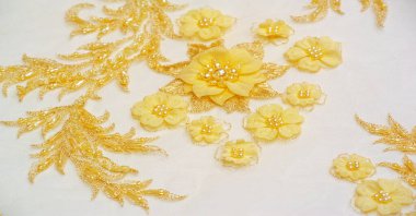 Dantel sarıdır. Doku. Geçmişi. şablon. Bu, altın işlemeli dantel kumaşa dikilmiş yüksek kaliteli sarı işlemeli bir nakış. kartpostal, poster, doku veya duvar kağıdı için kullan