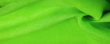 Yeşil ipek kumaş. İnce taneli Grunge yüzey dokusu, yeşil saten doku, zümrüt kumaş, ipek panorama, güzel, yumuşak doğal bulanık desenli.