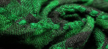 Doku, arka plan, desen. Bir insanın boynuna takılacak yün bir eşarp Eşarp üzerine yeşil siyah bir renk