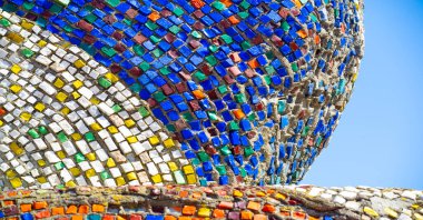 Eski mozaik. Beton bir yüzeyde çok renkli cam parçaları. Taş, kiremit ya da cam gibi sert bir maddenin küçük renkli parçalarını birleştirerek elde edilen bir desen..