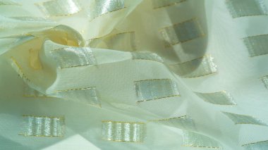 Altın bir çizgi, fildişi pastel, desenli arka plan, desenli kart ile sınırlandırılmış metal kare yerleştirilmiş ipek kumaş.