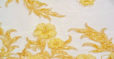 Dantel sarıdır. Doku. Geçmişi. şablon. Bu, altın işlemeli dantel kumaşa dikilmiş yüksek kaliteli sarı işlemeli bir nakış. kartpostal, poster, doku veya duvar kağıdı için kullan