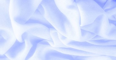 Mavi kumaş, lüks kumaşın soyut arkaplanı ya da dalgaların sıvı ipek dokusu ya da dalgalı kıvrımlar. arka plan ya da zarif duvar kağıdı tasarımı. Pamuk dokusu, doğal kumaş ve boya, parlak mavi renk.