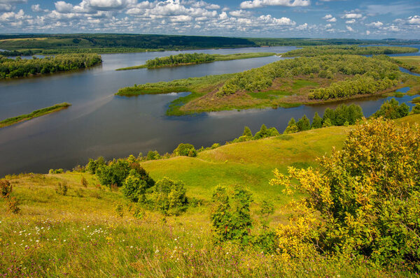 Summer landscape, river a large natural stream of water flowing in a channel to the sea, a lake, or another such stream. flood, nulla, effluent, ford. High hilly shores