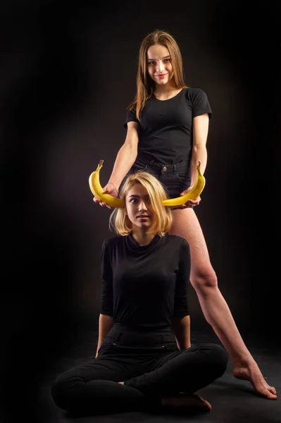 Dziewczyny Banan Czarnych Koszulkach Czarnych Spodenkach Ciemnym Tle — Zdjęcie stockowe