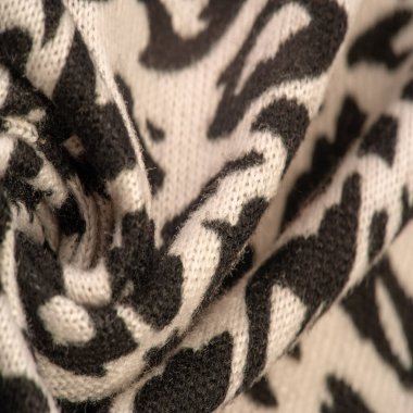 Doku, arkaplan, desen, kadın yün şalı, siyah ve bej, Afrika motifleri, yün ve modülden yapılmış, kenarları kıvrımlı bir yılan şeklinde..