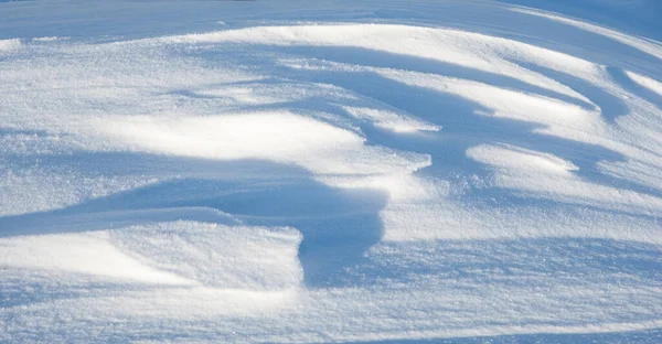 晴れた日に雪のテクスチャ 風が気まぐれなパターンを作成しました — ストック写真