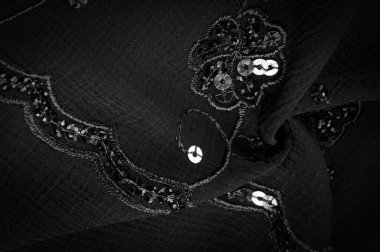 İpek siyahı. Kumaş pullarla süslenmiş. arka plan, ipek saten, lüks kumaş, koyu kumaş, kostüm pamuğu, soyut renk kalıbı, hassas sıvı kömür kadife.