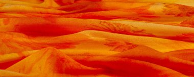 Boyanmış çayır çiçekleri ve çiçek arkaplanlı turuncu ipek kumaş. Renkli bir kompozisyonda bir sürü soluk çiçek. Arkaplan dokusu