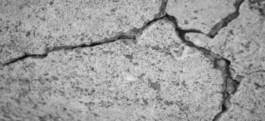 Yüzeyin derinliği. Fotoğraf bulanıklaştı. Çatlak beton. Betondaki çatlaklar, dış güçler, hacim değişiklikleri ve sürünme kaynaklı iç gerilim stresinden kaynaklanır..