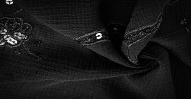 İpek siyahı. Kumaş pullarla süslenmiş. arka plan, ipek saten, lüks kumaş, koyu kumaş, kostüm pamuğu, soyut renk kalıbı, hassas sıvı kömür kadife.