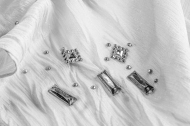 Süslü, süslemeli taşlı beyaz kumaş. parlak renkli taşlarla dokuma arkaplanı, doku arkaplan tasarımı. İpek deseni,