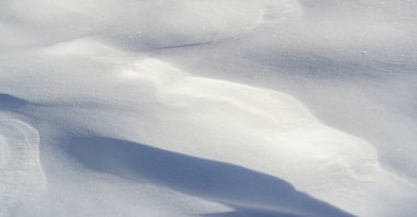 Snow texture atmospheric water vapor frozen into ice crystals and falling in light white flakes or lying on the ground as a white layer.