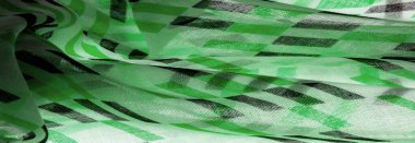 Yeşil ve siyah geometrik eşkenar dörtgen şekilli beyaz ipek kumaş. Soyut çizim frangı, yakın plan, tasarım için arka plan, klasik parlak desen. Doku. Geçmişi. Şablon.