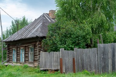 Old wooden house. Coniferous log house. Under the rising sun, wind and frost. a lot of time. the tree turned black from the weather.