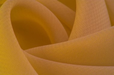 yellow silk polyester. Background from yellow silk fabric. Textured background made of transparent and light fabric for sewing clothes. Panorama from textiles. Texture. template.
