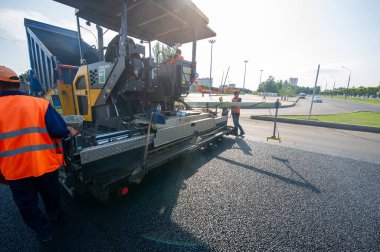 Yol yapımı. Bir inşaat sahasında, işçiler sıcak karışımı otoyola yayıp sıkıştırıyorlar. 1207 2021 Kzakhstan Orta Asya