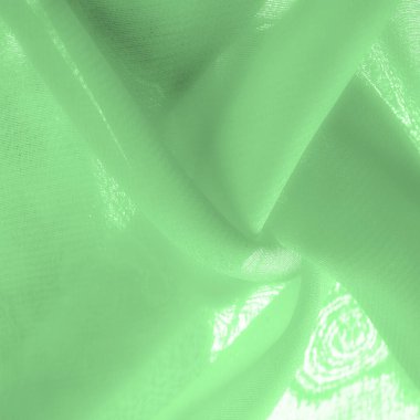 green silk fabric. thin, strong, soft, shiny fiber produced by silkworms. Texture. Background.