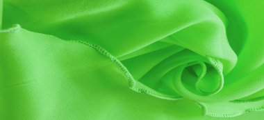 Dalgalı boruları olan yeşil ipek bir organza. Kumaşın kenarındaki sınır. Soyut arkaplan. doku deseni. İpek organzanın narin bir açık dokuması vardır. Dalga arkaplanı. Boşluğu kopyala