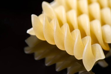 Short pasta. Fusilli, commonly known as rotini in the United States, is a variety of pasta that has a corkscrew or spiral shape. The word fusilli is believed to be derived from fuso (