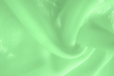green silk fabric. thin, strong, soft, shiny fiber produced by silkworms. Texture. Background.