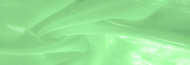 green silk fabric. thin, strong, soft, shiny fiber produced by silkworms. Texture. Background.