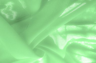 green silk fabric. thin, strong, soft, shiny fiber produced by silkworms. Texture. Background.