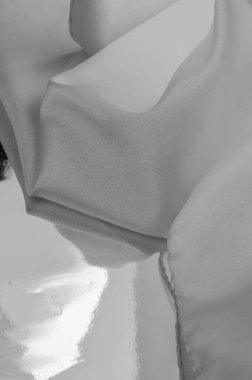 Tek renkli ipek kumaş, zarif, dalgalı, siyah beyaz saten ipek kumaş, soyut tasarım. arkaplan dokusu, desen