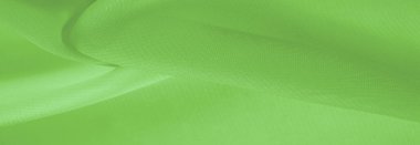 Açık yeşil ipek polyester. Kireç yeşili ipek kumaştan. Şeffaf arkaplan ve elbise dikmek için açık kumaştan yapılmış. Tekstil panoraması