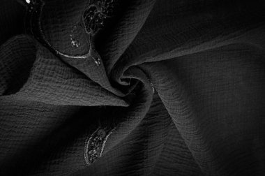 İpek siyahı. Kumaş pullarla süslenmiş. arka plan, ipek saten, lüks kumaş, koyu kumaş, kostüm pamuğu, soyut renk kalıbı, hassas sıvı kömür kadife.