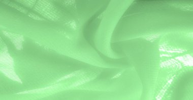 green silk fabric. thin, strong, soft, shiny fiber produced by silkworms. Texture. Background.