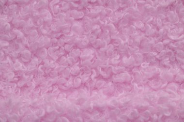 Soluk pembe renkli sahte kürk. Karakul kuzu derisinin taklidi. Görünüşü ve sıcaklığı hayvan kürküne benzeyen tüylü kumaş olarak bilinir..