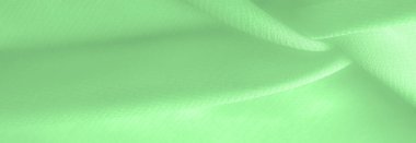 green silk fabric. thin, strong, soft, shiny fiber produced by silkworms. Texture. Background.