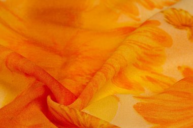 Boyanmış çayır çiçekleri ve çiçek arkaplanlı turuncu ipek kumaş. Renkli bir kompozisyonda bir sürü soluk çiçek. Arkaplan dokusu