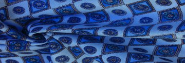 Yumuşak mavi ipekten kumaş eşkenar dörtgen, kare ve madalyalar. Bir hikaye anlat ve geleneksel tasarım ile etkileyici ve değerli bir açıklama yap. Desen arkaplan deseni