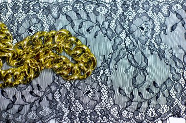 Beyaz arka planda siyah dantel. Bahçede siyah dantel süsleme. İç çamaşırı için kumaş. Tığ işi. Tasarımın. Kartpostal davetiyesi. doku arkaplan deseni. altın zincir