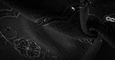 İpek siyahı. Kumaş pullarla süslenmiş. arka plan, ipek saten, lüks kumaş, koyu kumaş, kostüm pamuğu, soyut renk kalıbı, hassas sıvı kömür kadife.