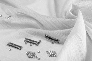 Süslü, süslemeli taşlı beyaz kumaş. parlak renkli taşlarla dokuma arkaplanı, doku arkaplan tasarımı. İpek deseni,