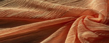 İpek kumaş. Kahverengi kırışık kumaş dokusu. Kahverengi buruşuk, dalgalı yüzey dokusu. Yakın çekim, yumuşak odaklanma. arkaplan, kalıp