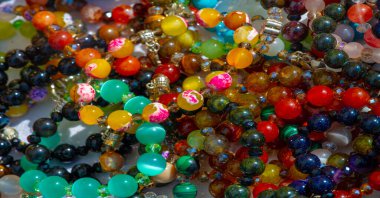 Doku, arka plan, desen. Halk sanatı. Çok renkli taş ve camlardan boncuklar.