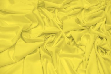 Kumaş sarı ipek. Doku. Geçmişi. Şablon. İpek kumaşın parlak bir parıltısı ve yatay olarak çalışan karakteristik küçük kıvrımları vardır. Yumuşak kıvrımlar içinde uzanır