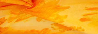 Boyanmış çayır çiçekleri ve çiçek arkaplanlı turuncu ipek kumaş. Renkli bir kompozisyonda bir sürü soluk çiçek. Arkaplan dokusu